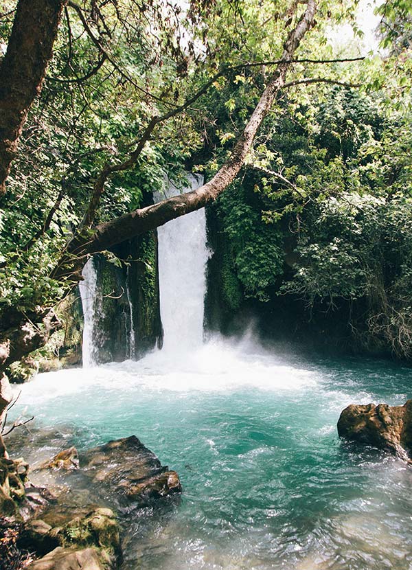 Serene waterfall with turquoise water surrounded by rocks, symbolizing healing and peace, reflecting how trauma therapy works.