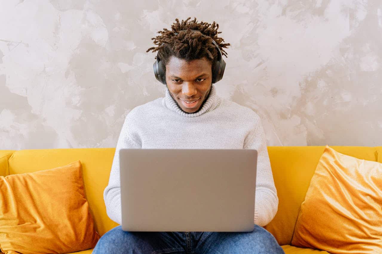 Person sitting at home using a laptop and headphones for an online EMDR therapy session