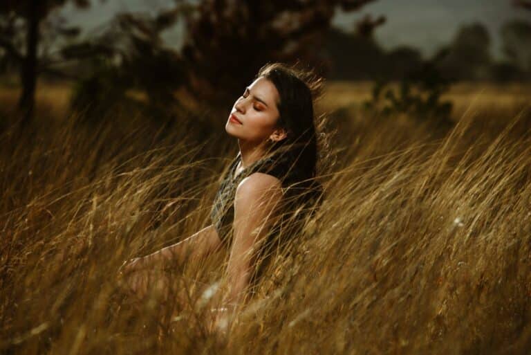 Woman sitting peacefully in nature, representing emotional healing and trauma focused CBT therapy support