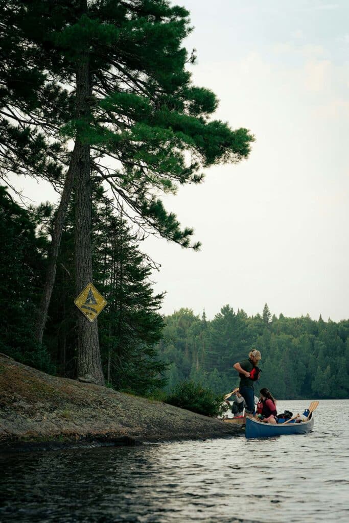  A couple kayaking on calm water surrounded by beautiful mountain scenery