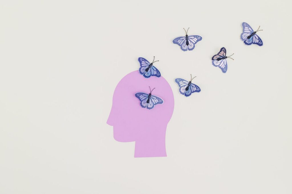 Head silhouette with butterflies symbolizing internal healing and trauma recovery in CBT vs IFS therapy