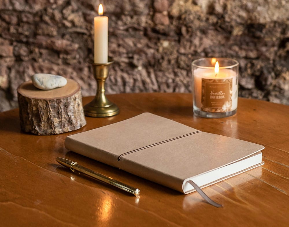 Open a diary with a pen and candles on a table, a calm, reflective space for journaling and personal thoughts