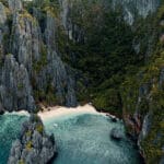 Wide ocean view with mountains in the distance under a clear sky, creating a peaceful natural landscape