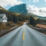 Open road stretching through a city with buildings on both sides, leading forward, representing direction, movement, and change.