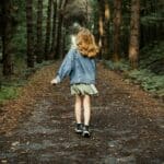  A young girl walking along a forest path symbolizes growth, journey, and moving forward with support.