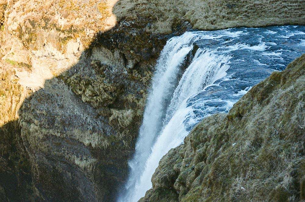 a powerful waterfall plunges over a rugged cliff